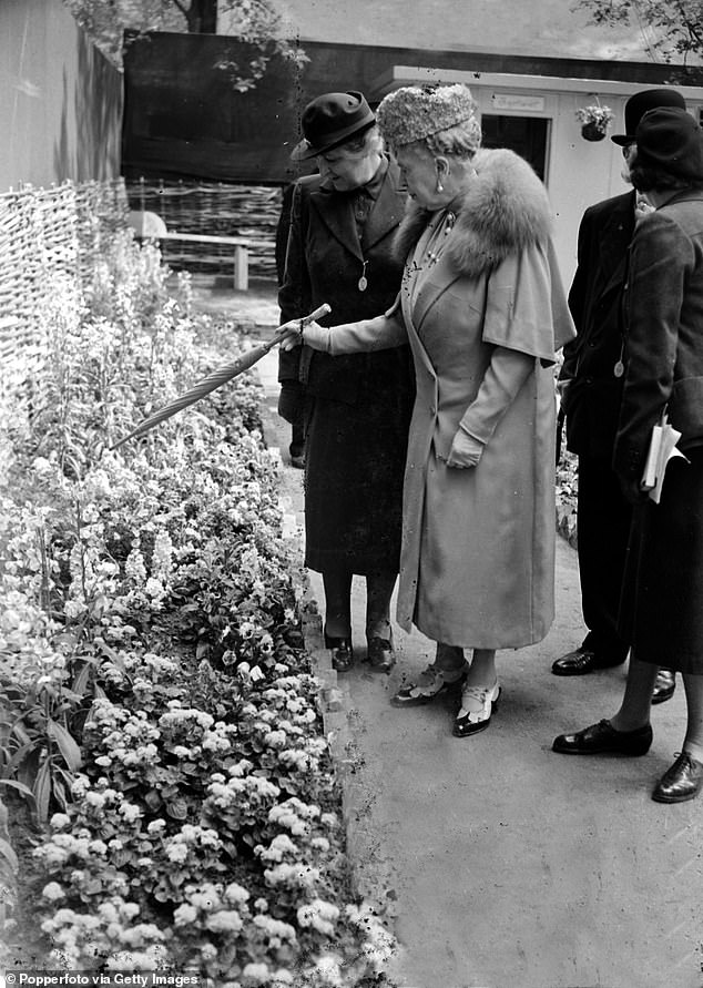 Королева Мария указывает на экспонат на выставке цветов в Челси в 1950 году.